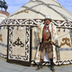 a man in ethnic costume in front of a yurt